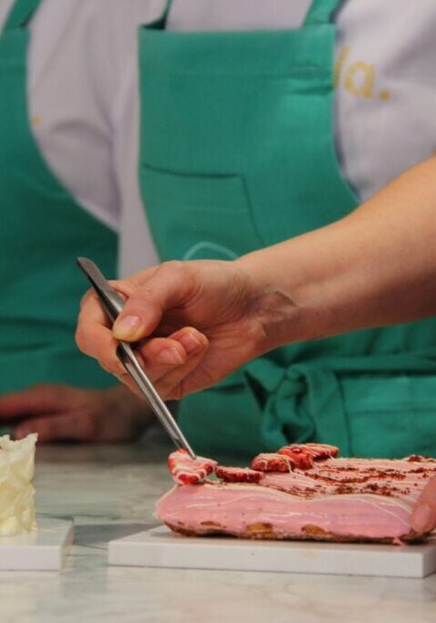 Pastry chefs in aprons carefully decorating an elegant wedding cake with precision and artistry